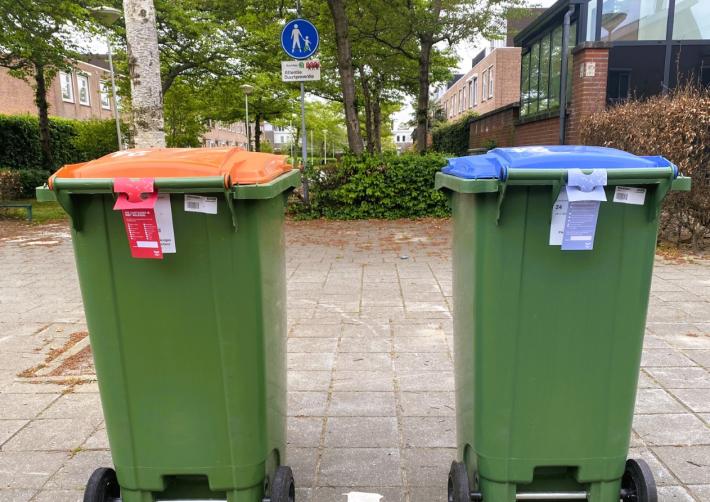 rode kaart en attentiekaart aan afvalcontainer