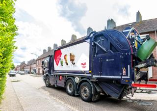 Afval inzamelende vuilniswagen met op zijkant sticker 'Afval scheiden we samen'